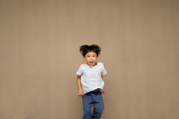 The boy is jumping on the bed.