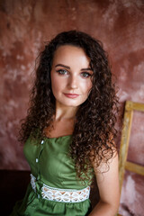 Portrait of a beautiful smiling woman of European appearance in a dress with curls hairstyle. Fashion and beauty