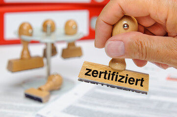 Stempel in Hand mit Aufschrift zertifiziert