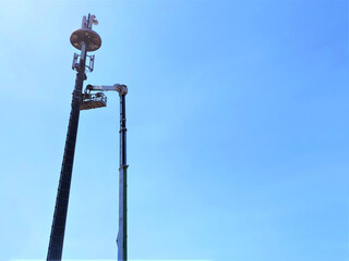 Telecommunication tower with antennas against blue sky background with copy space.