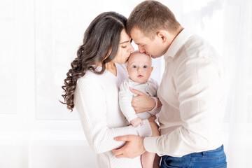happy parents kissing a child, happy family concept, lifestyle