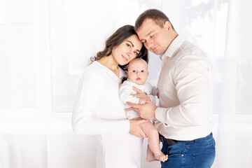 Fototapeta premium happy family mother and father hold a newborn baby at home, the concept of happy loving family, lifestyle