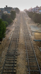 Fototapeta na wymiar Parallel railway tracks leading into the foggy morning
