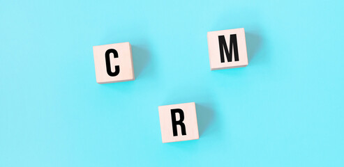 Concept word CRM business to business on cubes on a beautiful blue background. Business concept. Copy space.