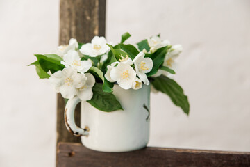 jasmine flowers in rustic metal cup.