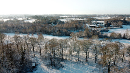 Fototapeta na wymiar Aerial snow covered Solihull park and woodland scene, United Kingdom from drone