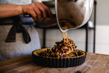 Pecan pie mixture being poured into a pastry case