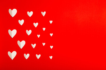 Valentine's Day composition. White paper hearts on red background in flat lay style. Valentines day concept, photo template