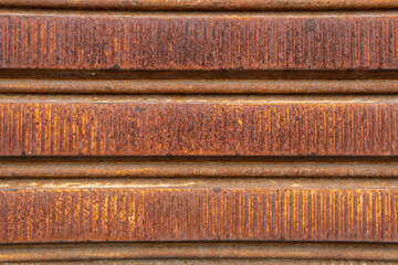Close-up of a rusted and deteriorated metal fence