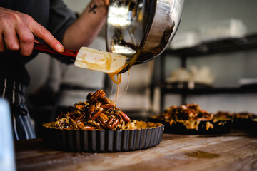 Pecan pie mixture being poured into pastry cases