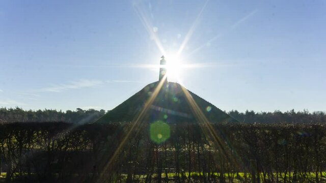 wide shot Time lapse of sun appearing behind obelisk on Austerlitz Pyramid. The Piramide van Austerlitz is a monument built in 1804 as a tribute to Napoleon Bonaparte.