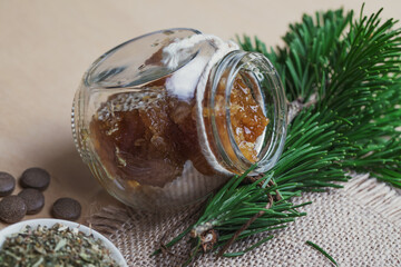 Tablets from natural ingredients, phyto pharmacy. A jar of honey, a bouquet of pine branches and herbal tea. Elements of traditional medicine.