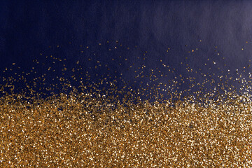 golden glitter sparkles dust texture on blue paper background
