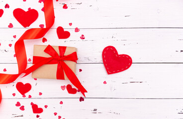 Red hearts and ribbon on white wooden background