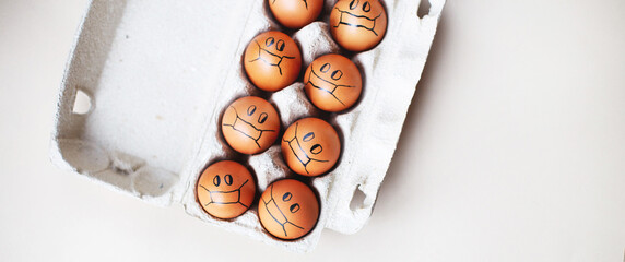 chicken eggs with drawn medical mask on egg carton on white background. Easter eggs holidays decoration. banner