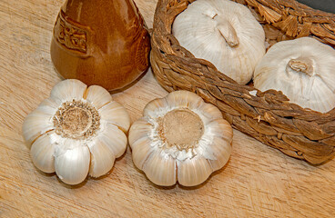 Fresh garlic on the wooden table and wicker basket,
Selective focus.
Top side view.
