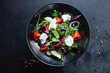Greek salad vegetables and feta cheese portion on the table for healthy meal snack outdoor top view copy space for text food background rustic image keto or paleo diet