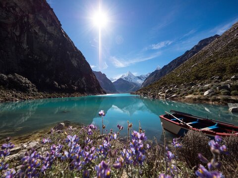 Blue turquoise alpine mountain lake Laguna Paron boat flower reflection in Caraz Huaraz Ancash Cordillera Blanca Peru