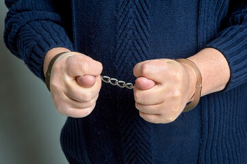 men's hands in handcuffs show a fig	