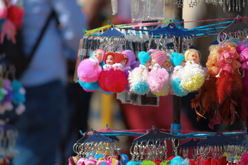 Zoom-in shot of doll figure keychains sold in a fair.