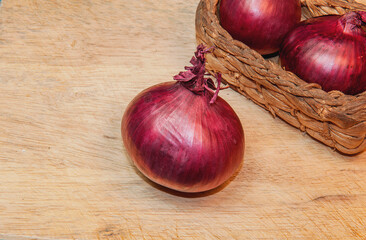 Red Onions on light wooden table background with copy space for text, selective focus.
Top view.