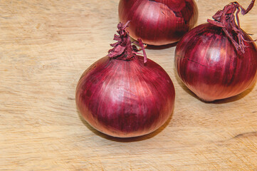 Red Onions on wooden background with copy space for text, selective focus.
Top view.