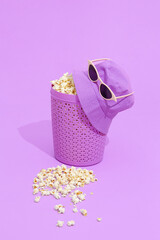 Minimal monochrome purple popcorn bucket and hat with sunglasses.  Still life design.  Fashion Home cinema concept