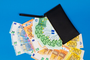 20, 50, 100, 200 Euro banknotes in a black leather wallet close-up. The concept of cash, cash savings, prosperity. Euromoney