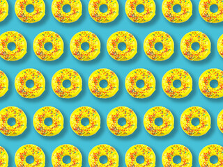 Pattern of yellow donuts with multi-colored sprinkles on a blue background.