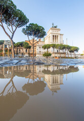 Obraz premium Rome, Italy - in Winter time, frequent rain showers create pools in which the wonderful Old Town of Rome reflect like in a mirror. Here in particular Via dei Fori Imperiali