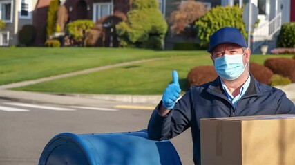 American postal worker wearing a protective mask and gloves with cardboard shipping box giving a thumbs up