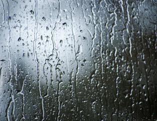Rain drops on window glasses surface with bokeh background.