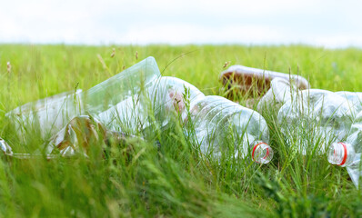 Pollution problem. Closeup used  plastic wast lying on green grass..Environmental pollution,...