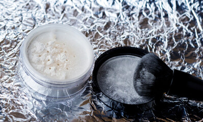 White loose powder with black brush. Powder for matting the skin.