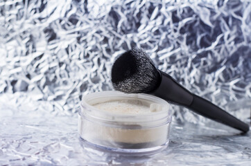 White loose powder with black brush. Powder for matting the skin.