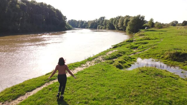 young happy woman running to river enjoying the view