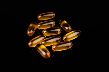 Omega-3 capsules on a black background. Health concept with fish oil capsules.