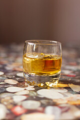 Glass of whiskey on the table with dark background