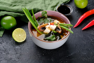 Misosup with mushrooms on a black background