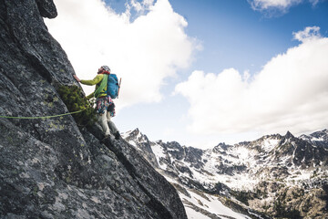 Man lead climbing on alpine rock route in Washington