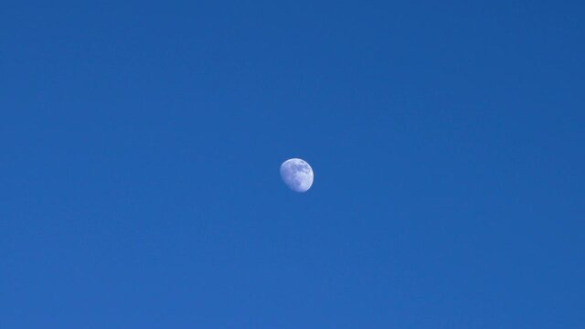 moving white moon on clear dark blue sky