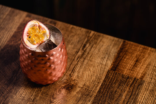 Cocktail in a short copper tumbler topped with fruid