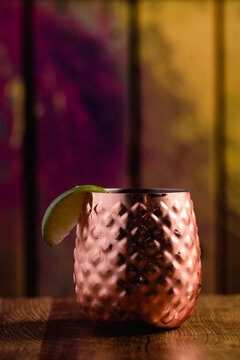 Cocktail in a short copper tumbler topped with fruid