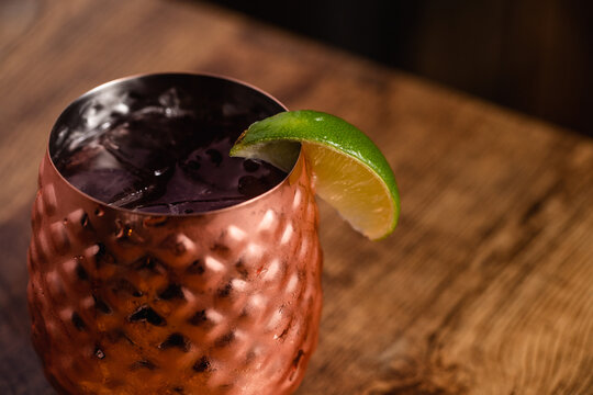 Cocktail in a short copper tumbler topped with fruid