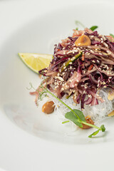 Asian noodle salad with beetroot and a lemon wedge