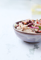 Salad with tuna and cherry tomatoes. Wooden background. Close up. Copy space.