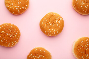 The burger buns on a pink background.