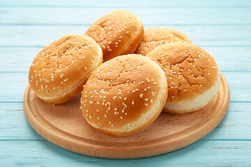 Burger buns on cutting board on a blue wooden background.