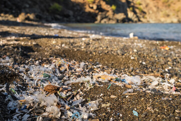 Small plastic parts and microplastics on the sand beach