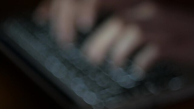 Typing on backlit keyboard at night  - coding, cyber terrorism, home office, freelance work concept